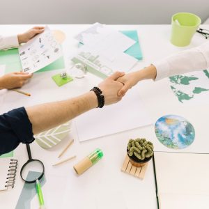 businessman-shaking-hands-with-his-partner-desk_23-2147826552