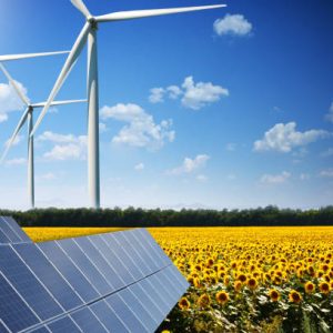 Green energy concept with solar panels and wind turbines on a sunflower field